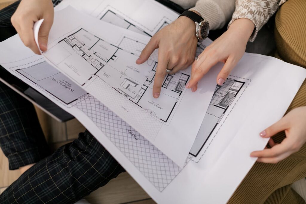 pexels-photo-7641913 Two people examining architectural blueprints, focusing on project details.